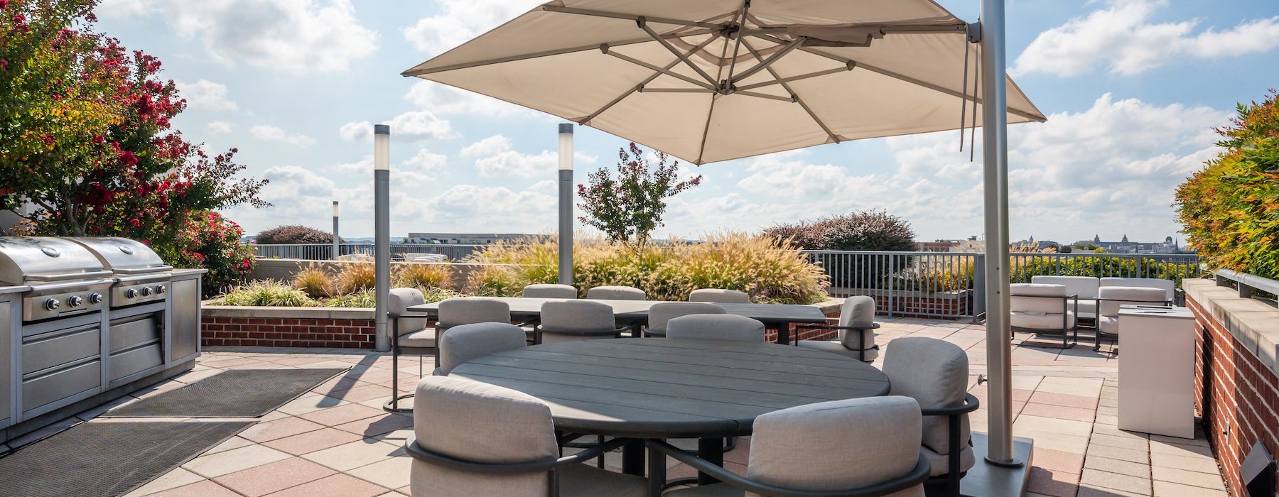 a rooftop grill area with a table and chairs