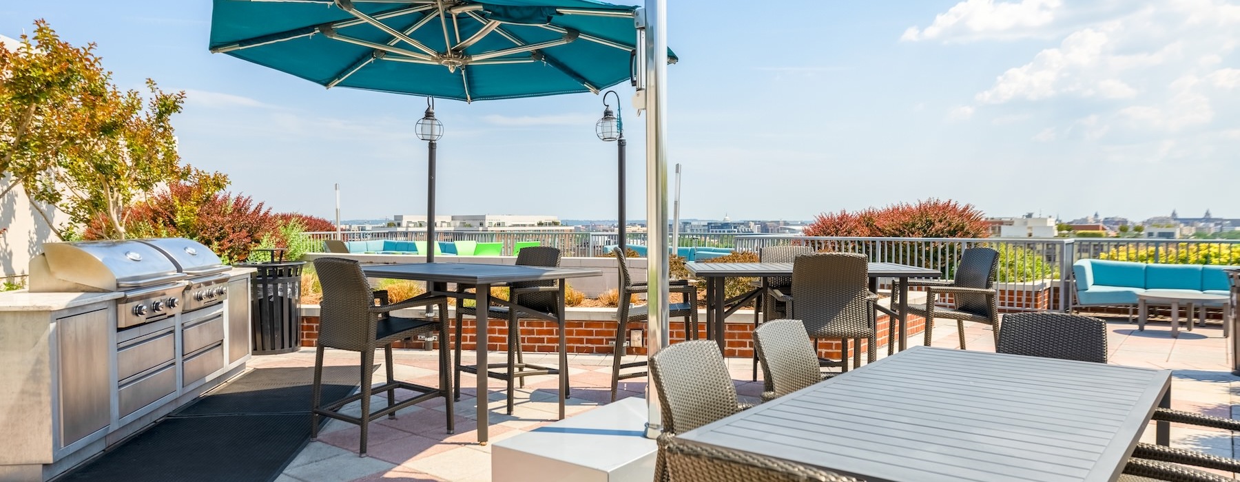 a rooftop grill area with tables and chairs