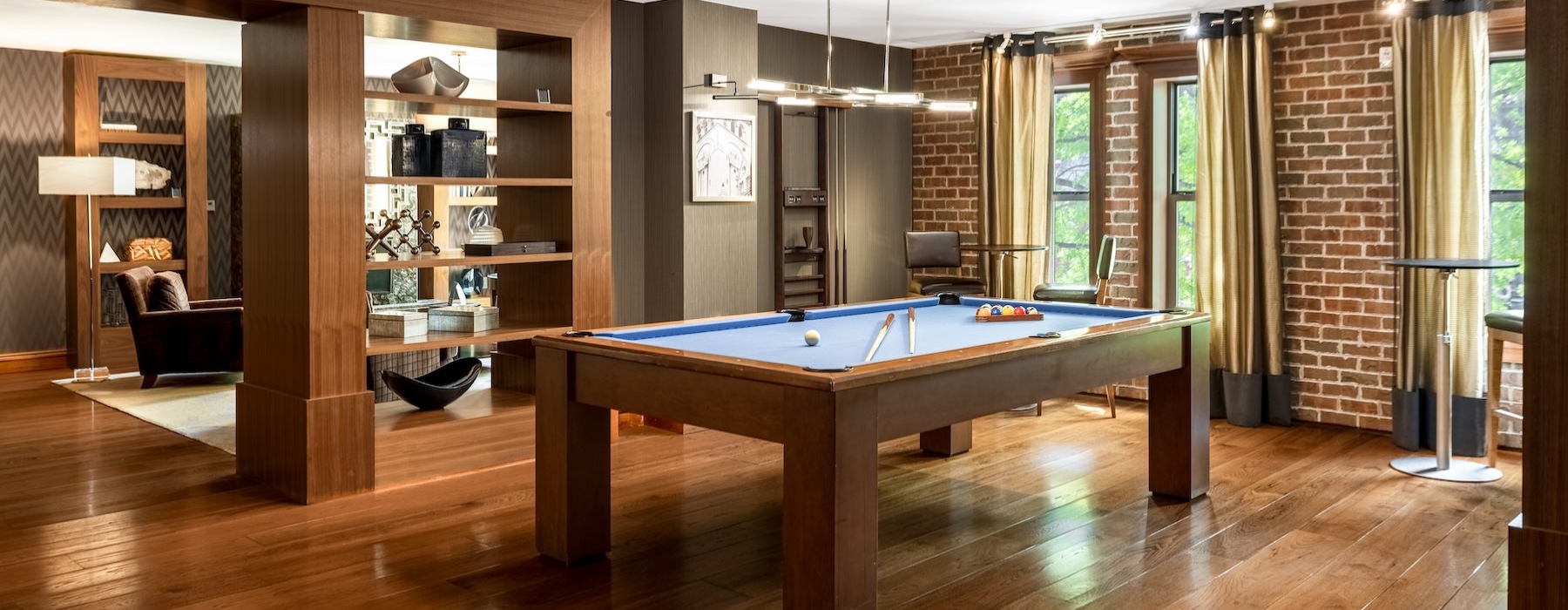 a clubroom with a pool table and wood floors