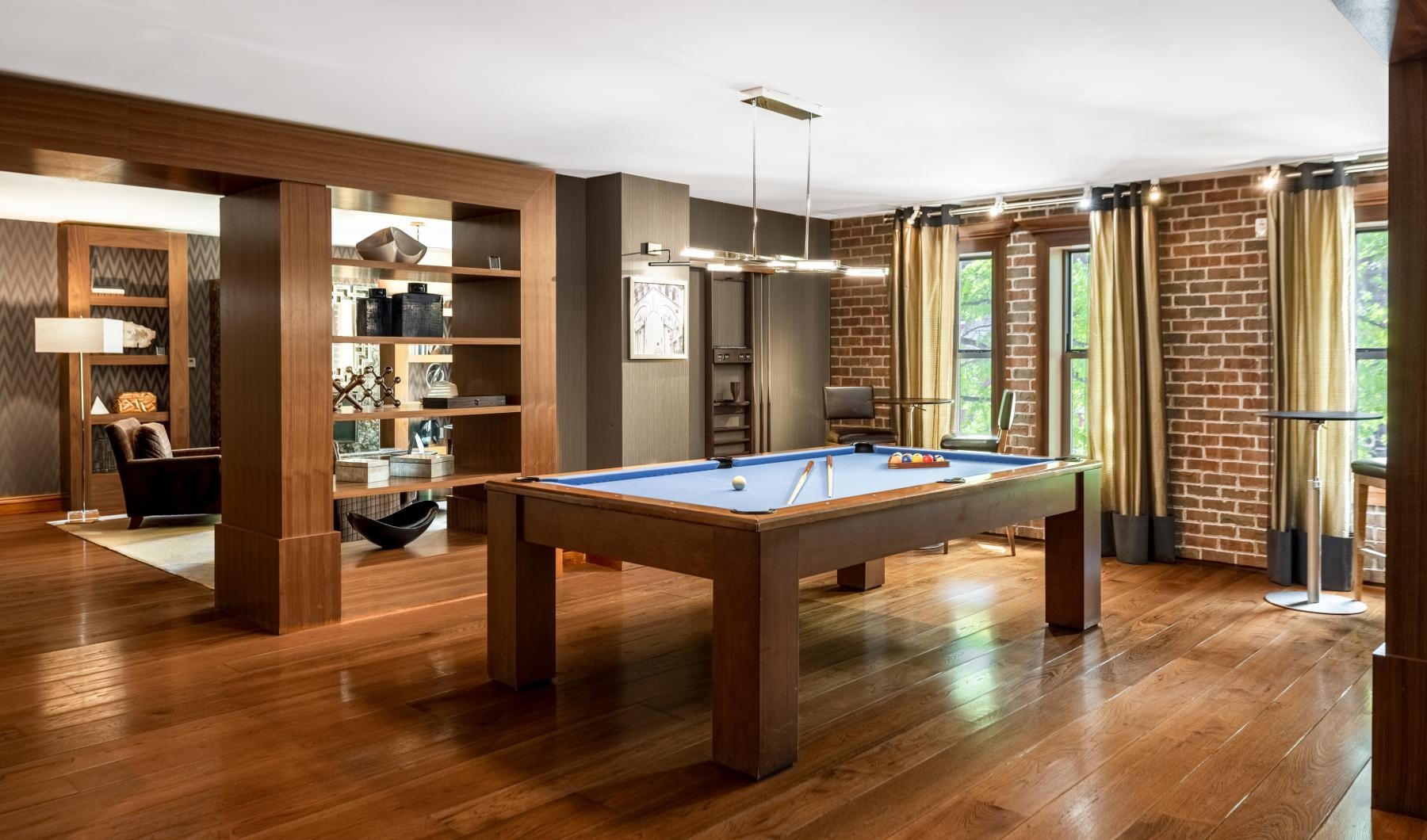 a room with a pool table and shelves with books on it