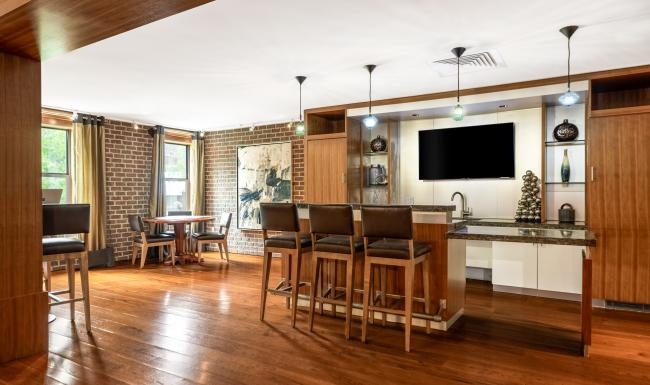 Cutting-edge amenities at your fingertips a clubroom kitchen with a tv and chairs